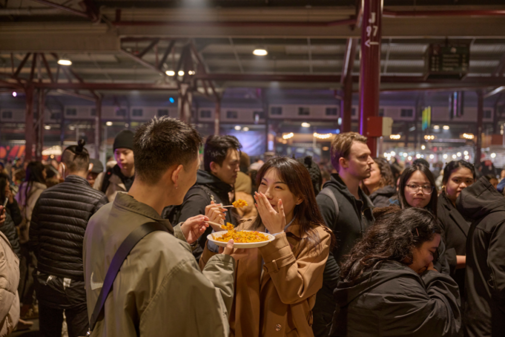 People eating food at Winter Night Market. Image via Visit Victoria