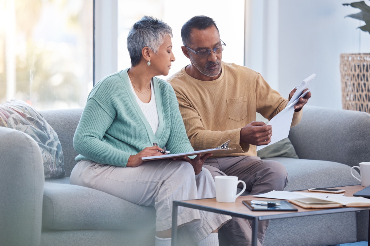 Couple looking through documents. Photography by PeopleImages.com - Yuri A. Image via Shutterstock