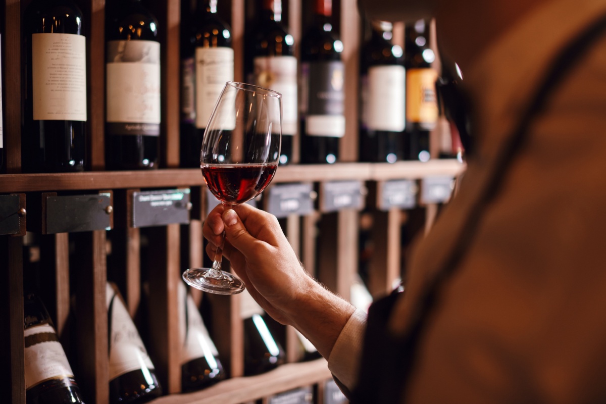 Person browsing wine store. Photography by Shakirov Albert via Shutterstock