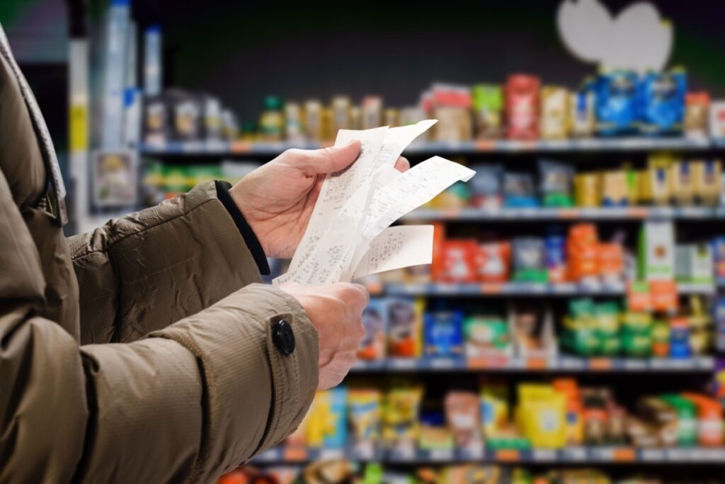 Person looking at grocery receipt. Photography by Denys Kurbatov via Shutterstock