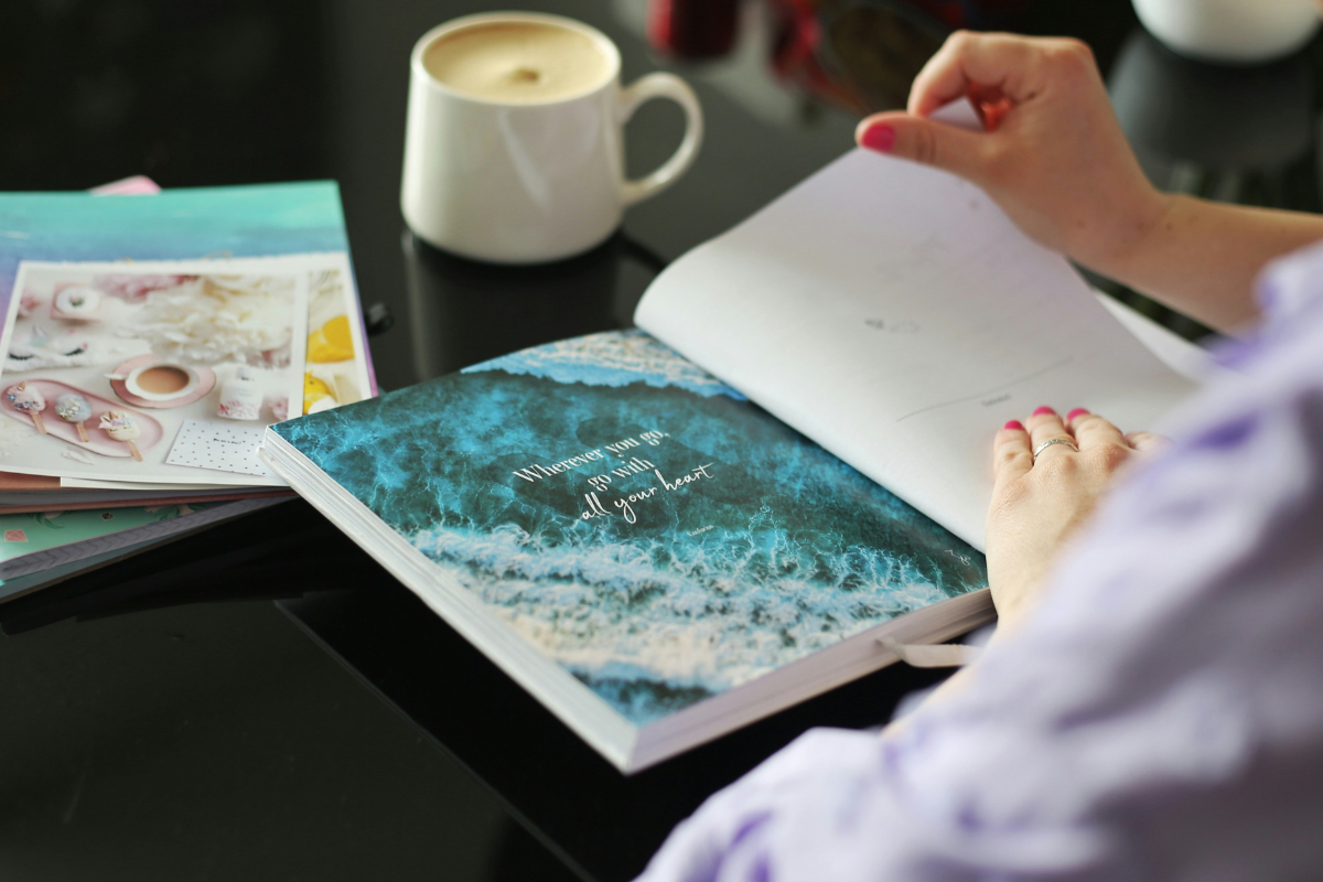 Person reading travel book. Photography by Andrijana Bozic via Unsplash
